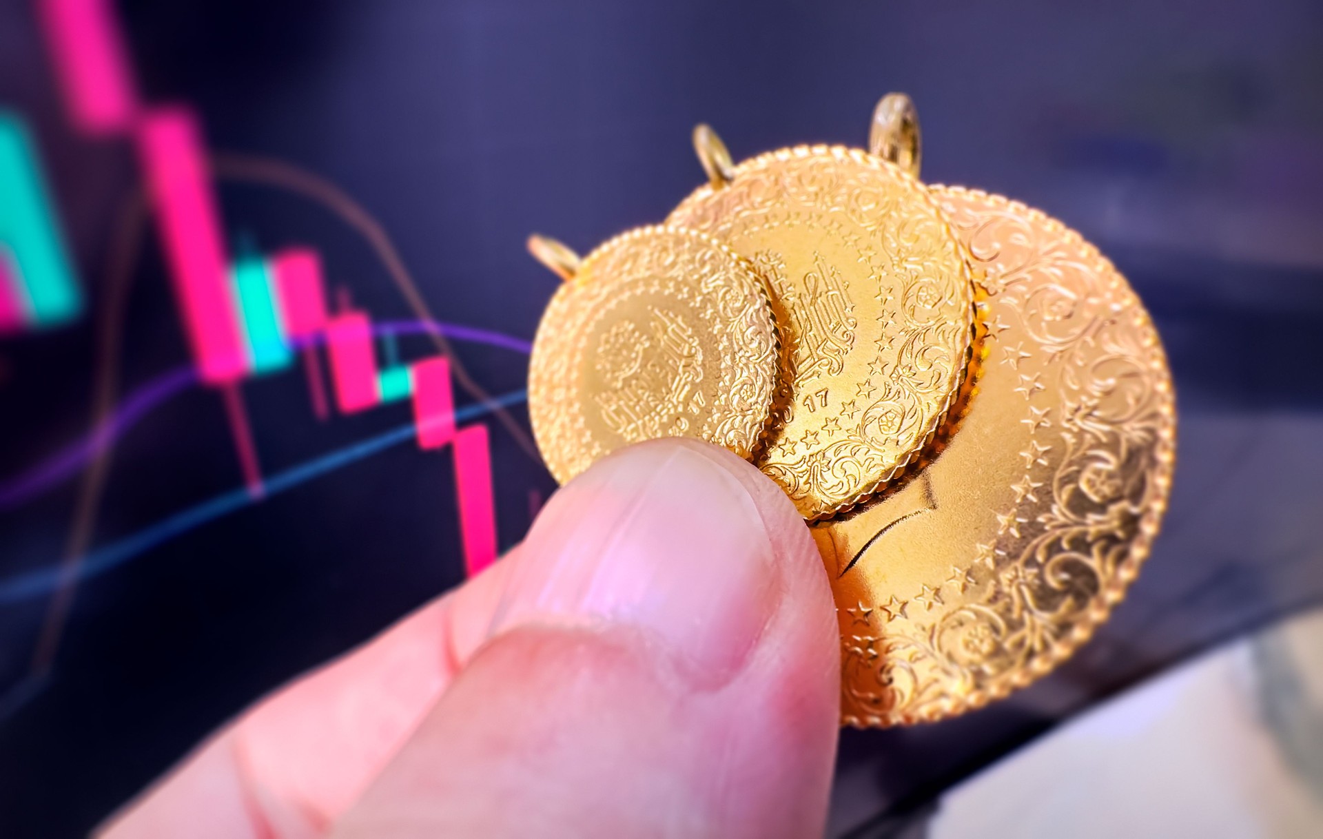 Human hand holding Turkish Gold coins on finance chart background